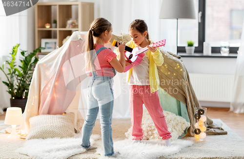 Image of girls with guitar and microphone playing at home