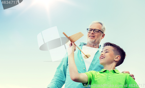 Image of senior man and boy with toy airplane over sky