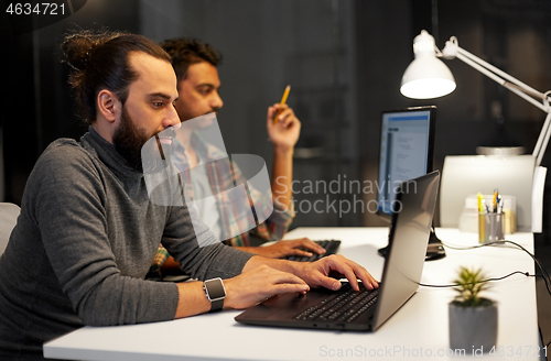 Image of creative team with computer working late at office