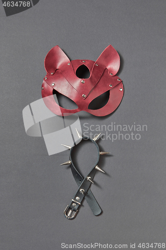 Image of Leather collar with sharp spines and cat BDSM mask on a black background.