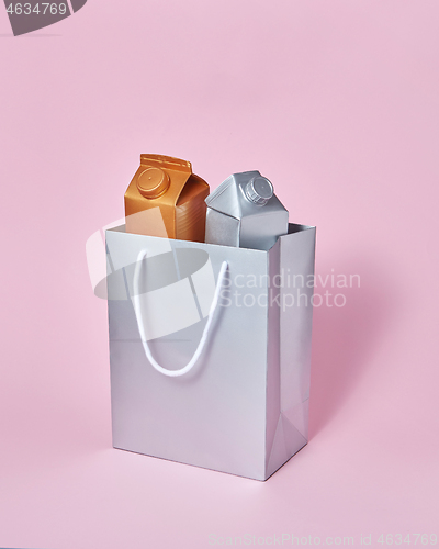 Image of Mock-up silver paper bag with two milk packages on a pink background.