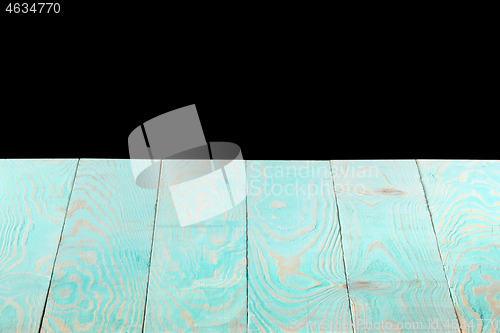 Image of Blank blue wooden textured table on a black background.