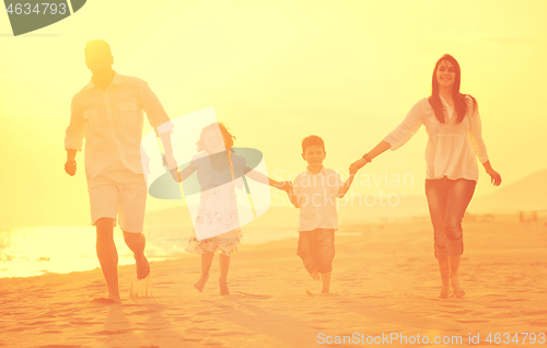 Image of happy young family have fun on beach at sunset