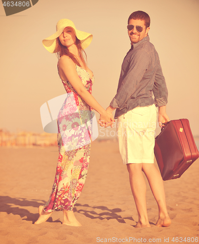 Image of couple on beach with travel bag