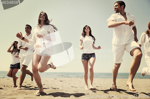 Image of happy people group have fun and running on beach