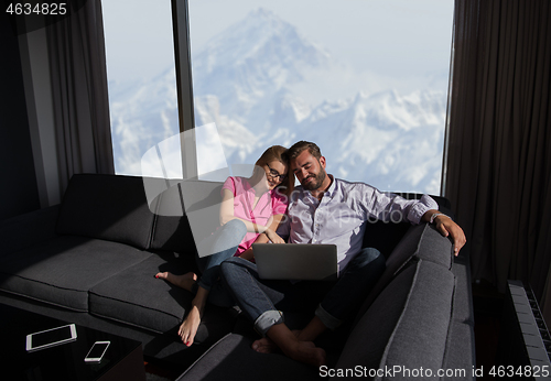 Image of couple relaxing at  home using laptop computers