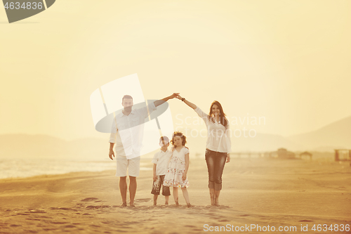 Image of happy young family have fun on beach at sunset