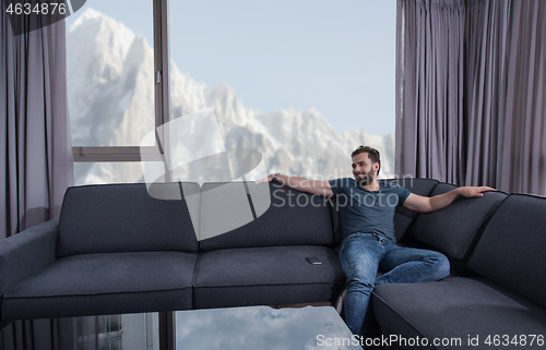 Image of young casual man using a mobile phone at home