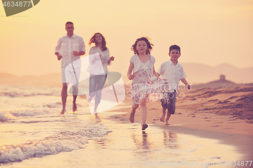 Image of happy young family have fun on beach at sunset