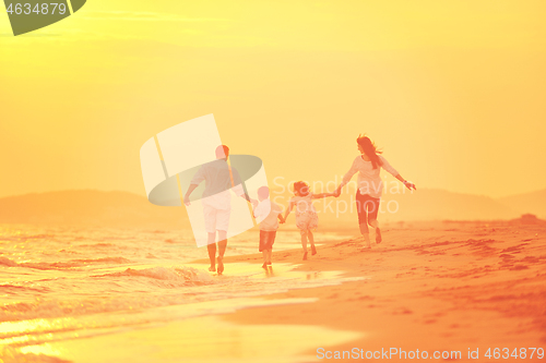 Image of happy young family have fun on beach at sunset