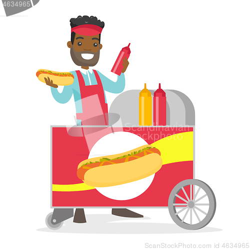 Image of African-american street seller making a hot dog.