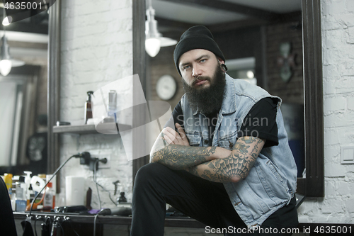 Image of The male hairdresser against a barber shop background.