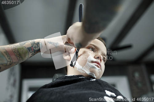 Image of Children hairdresser cutting little boy against a dark background.