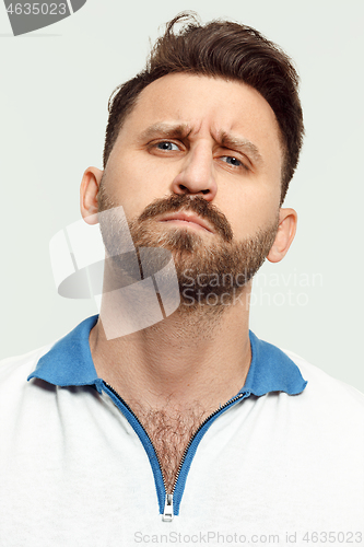 Image of The serious man standing and looking at camera against white background.