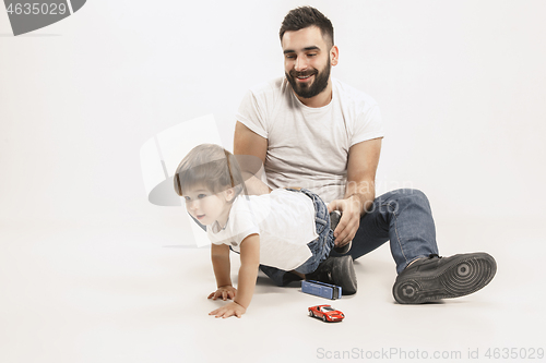 Image of happy family with kid sitting together and smiling at camera isolated on white