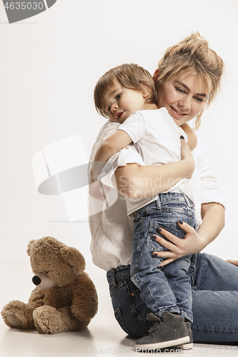 Image of happy family with kid sitting together and smiling at camera isolated on white