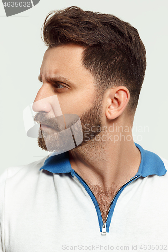 Image of The serious man standing and looking at camera against white background.