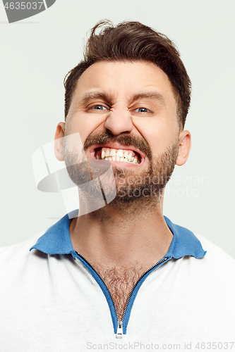 Image of The young emotional angry man screaming on studio background