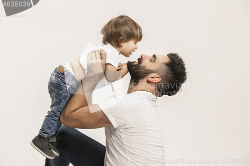 Image of happy family with kid sitting together and smiling at camera isolated on white