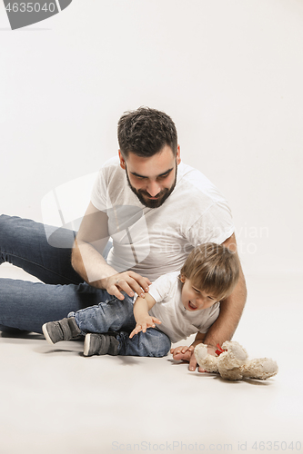 Image of happy family with kid sitting together and smiling at camera isolated on white