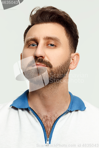 Image of The serious man standing and looking at camera against white background.