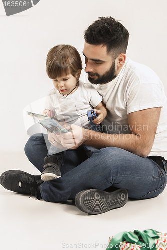 Image of happy family with kid sitting together and smiling at camera isolated on white