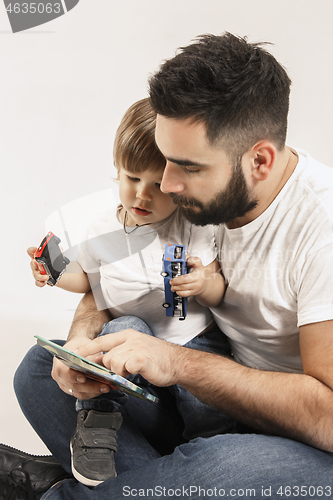 Image of happy family with kid sitting together and smiling at camera isolated on white