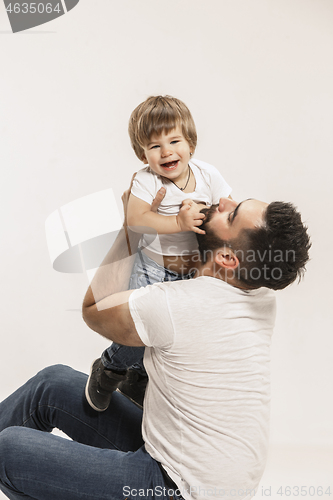 Image of happy family with kid sitting together and smiling at camera isolated on white
