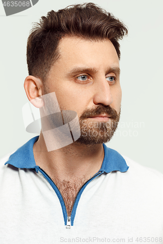 Image of The serious man standing and looking at camera against white background.