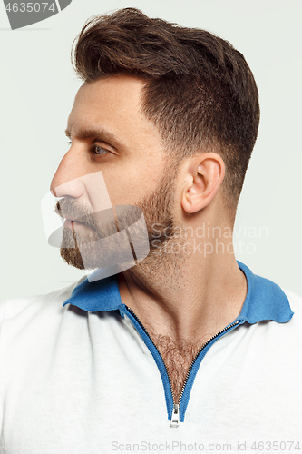 Image of The serious man standing and looking at camera against white background.