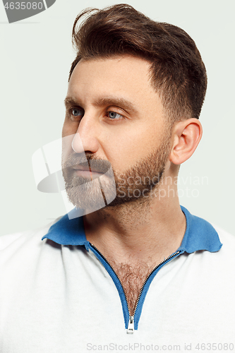 Image of The serious man standing and looking at camera against white background.