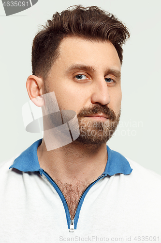 Image of The serious man standing and looking at camera against white background.