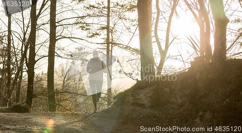 Image of Corona virus, or Covid-19, is spreading all over the world. Portrait of caucasian sporty woman wearing a medical protection face mask while running in nature.