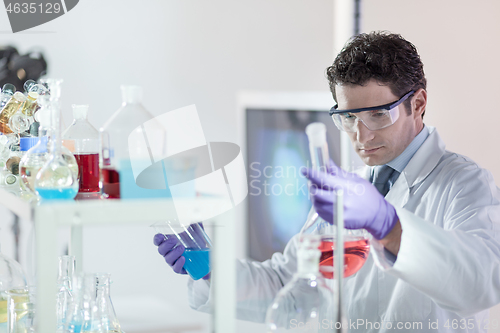 Image of Researcher performing scientific experiment in chemical laboratory.