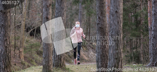 Image of Corona virus, or Covid-19, is spreading all over the world. Portrait of caucasian sporty woman wearing a medical protection face mask while running in nature.