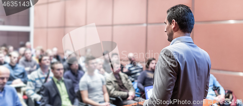 Image of Public speaker giving talk at business event.