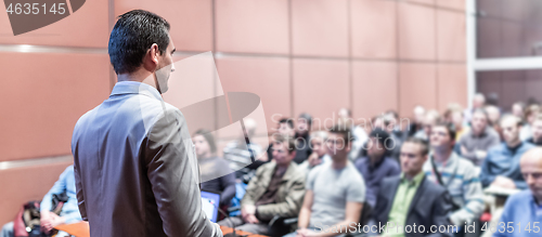 Image of Public speaker giving talk at business event.