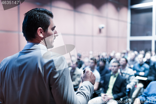 Image of Public speaker giving talk at business event.