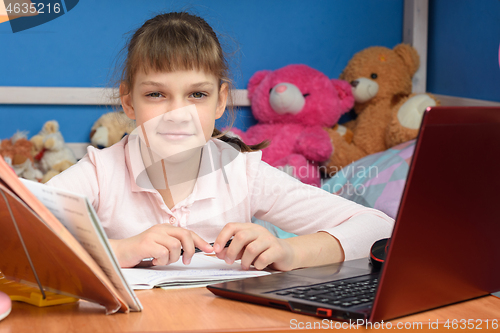 Image of remote learning at home with a laptop and a textbook