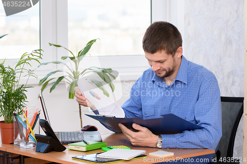 Image of Office clerk reads documents in a folder