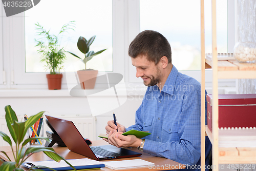 Image of Office employee takes notes in a diary