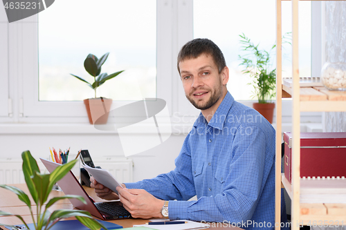 Image of Business man distracted from papers and looked into the frame