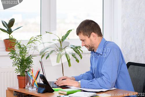 Image of Office worker is typing on a laptop