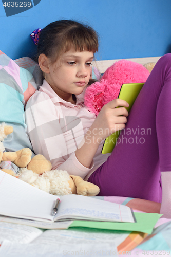 Image of Girl in bed learns remotely at home