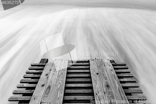 Image of A breaking pier and surf washed out with a long exposure, black and white photo