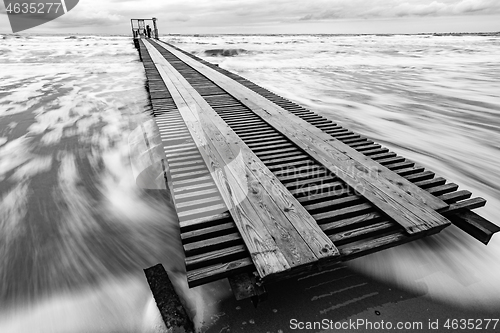 Image of Long distance pier on the sea coast, black and white photo, long exposure