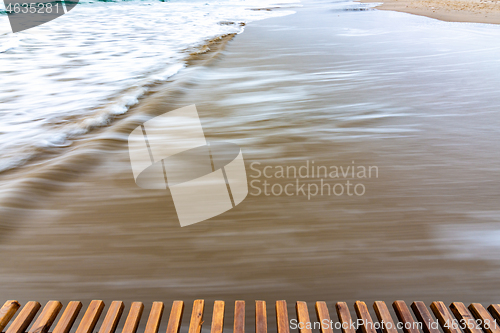 Image of Sea surf rolling ashore after sunset, blurry with a long exposure