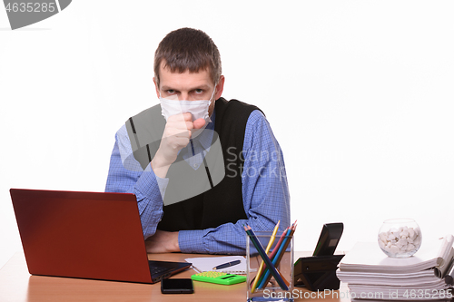 Image of Office worker in a protective mask coughs in the office