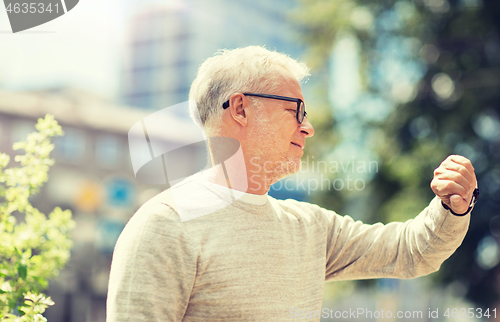 Image of senior man checking time on his wristwatch