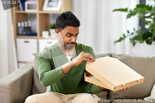 Image of indian man looking inside of takeaway pizza box